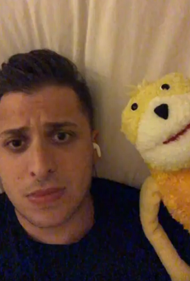 A photo of jordan lying on a sheet with a yellow puppet